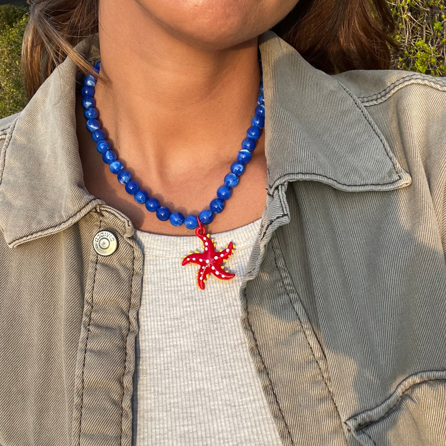 Collar Estrella, con un Dije de Vidrio en forma de Estrella Roja y Perlas Azules
Ulibkas