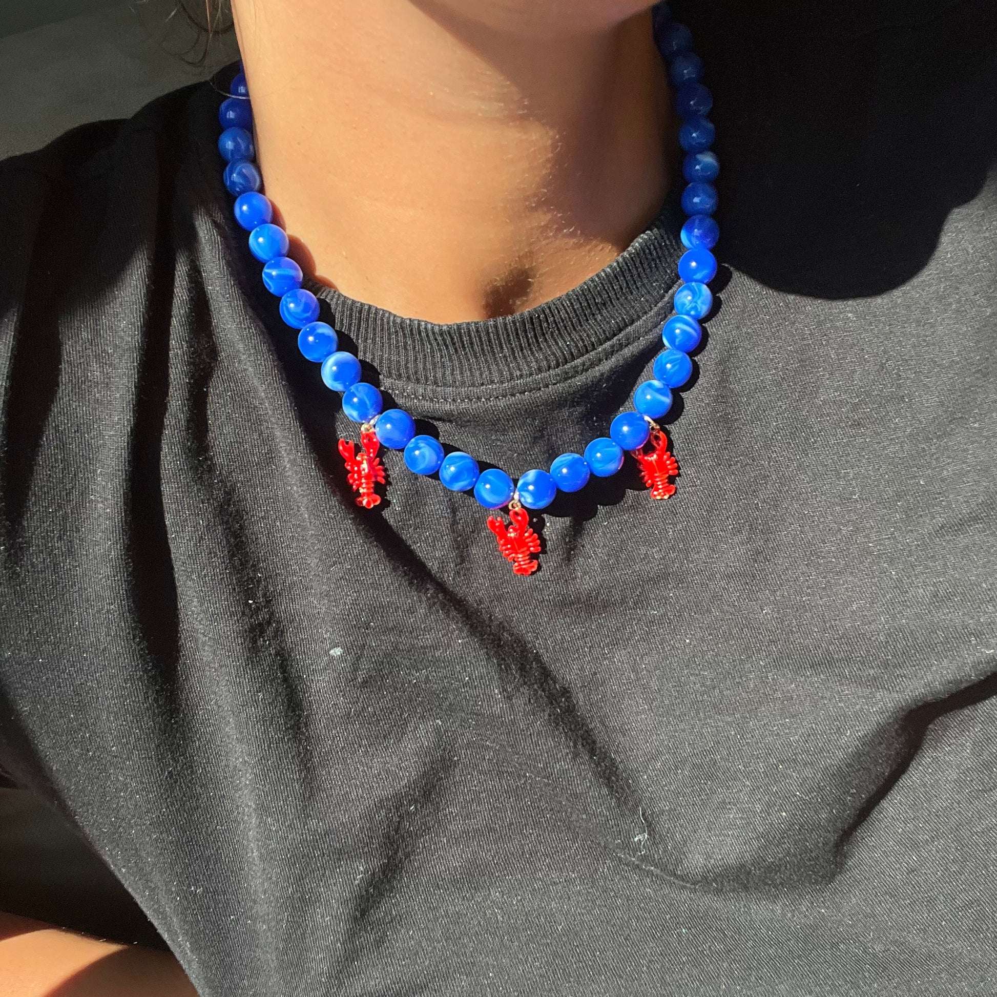 Collar Langostas, con Dijes en forma de Langostas Rojas y Perlas Azules
Ulibkas